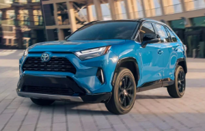 A blue 2024 Toyota RAV4 Hybrid parked in front of a building near Noblesville, Indiana