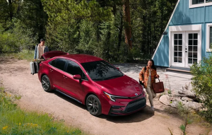 Two people packing up their 2025 Toyota Corolla parked next to their house near Noblesville, Indiana