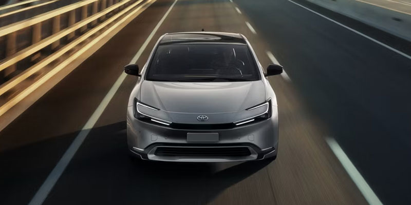 2026 Toyota Prius driving on highway, front view.