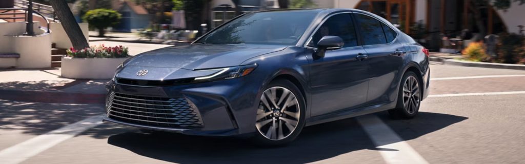 Toyota sedan driving on city street