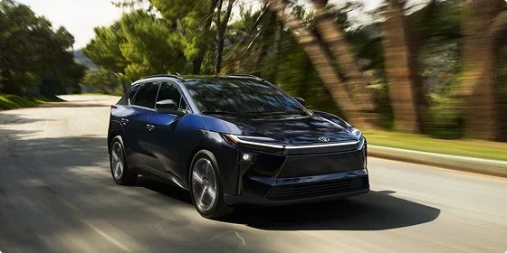2026 Toyota bZ Limited AWD driving on a tree-lined road