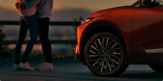 Front wheel and fender of a red 2026 Toyota C-HR XSE AWD at sunset