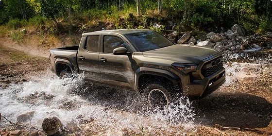 2026 Toyota Tacoma SR5 4x4 driving through water on a rocky trail