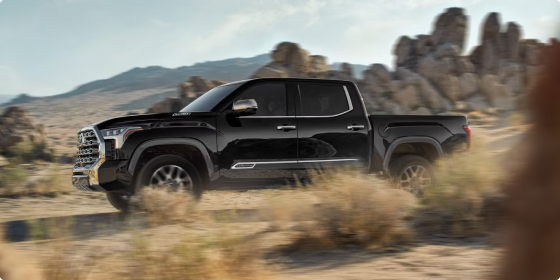 Black 2026 Toyota Tundra CrewMax driving on a desert trail