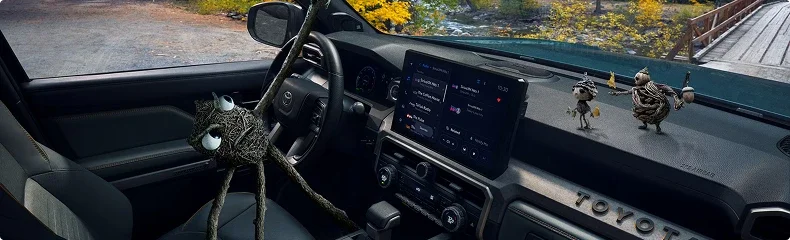 4Runner dashboard and wide touchscreen seen from the passenger side, with woodland through the windshield