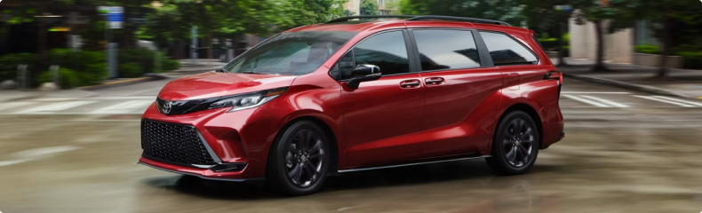 Red Toyota Sienna cornering on a city street