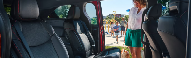 Toyota Sienna cabin seen through an open sliding door as a woman walks up with a bag