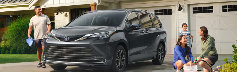 Gray Toyota Sienna on a driveway as a family washes it
