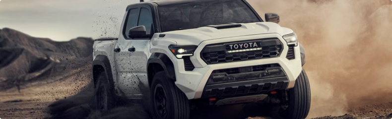 White Toyota Tacoma TRD Pro throwing up dirt on a desert track