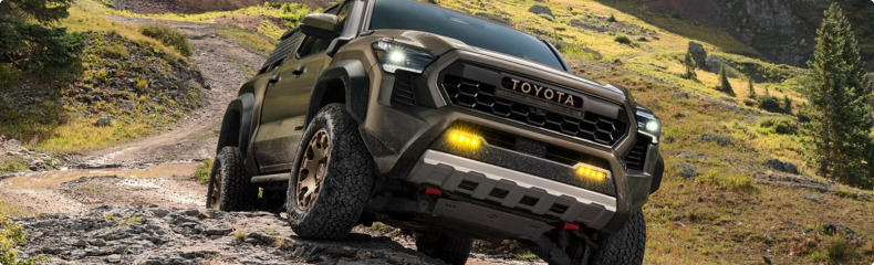 Green Toyota Tacoma Trailhunter working up a rocky mountain trail